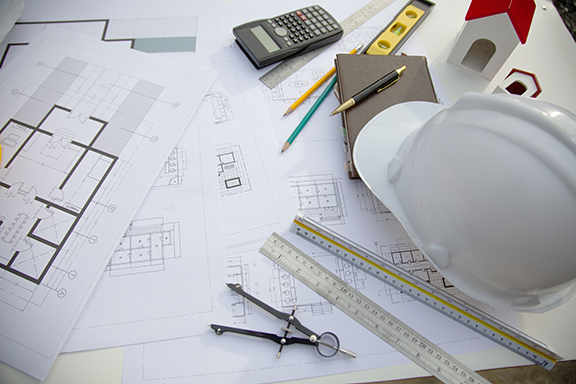 Architecture plans with tools such as rulers, level, calculator, pens, and notebook