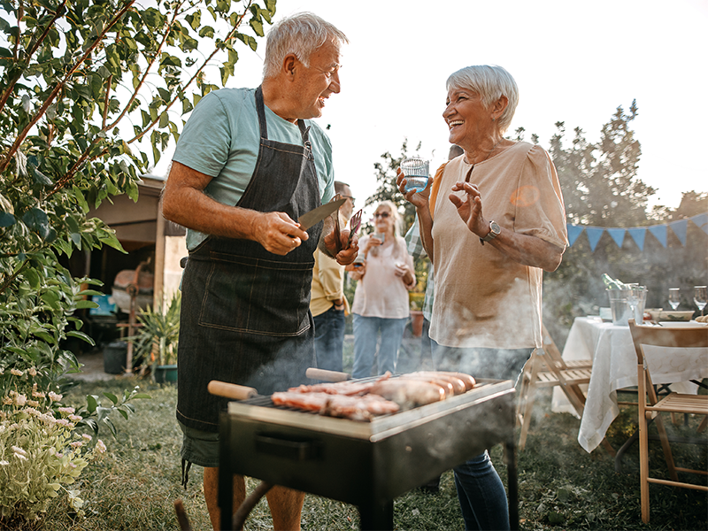 Seniors grilling BBQ outdoors at a Summer Event