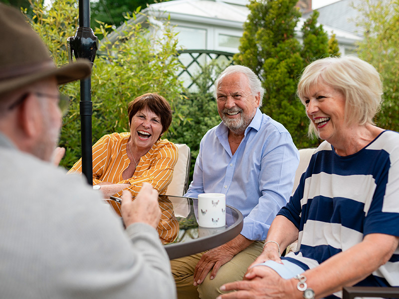 Group of seniors socializing at outdoor table
