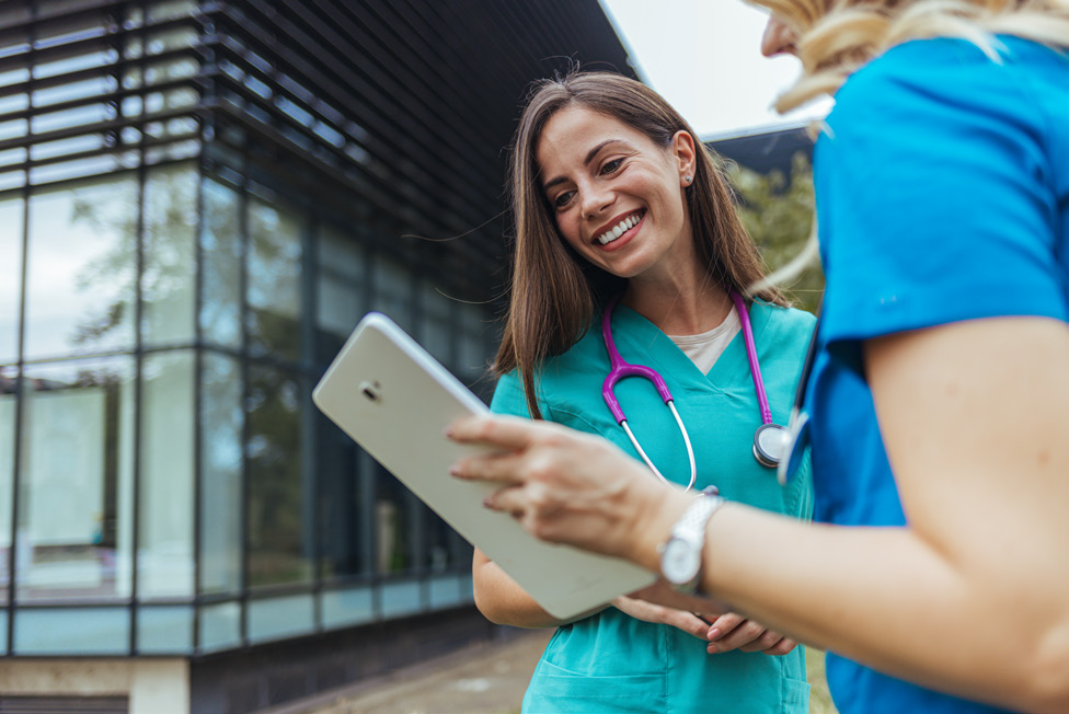 2 female nurses looking at tablet
