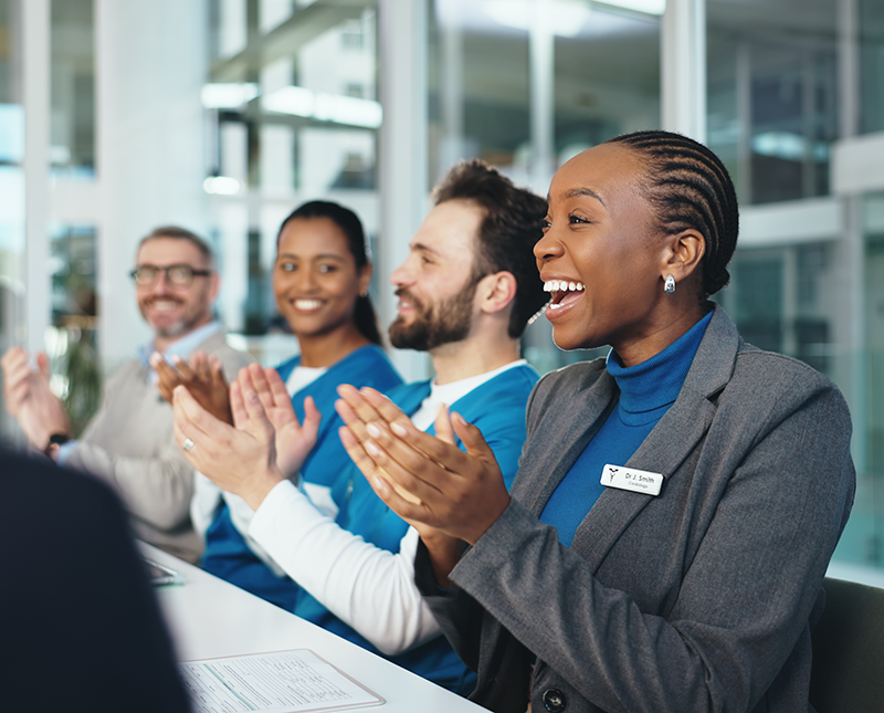 Staff members clapping and cheering in a meeting
